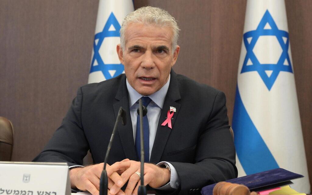 Prime Minister Yair Lapid, wearing a pink ribbon for breast cancer awareness, leads the weekly cabinet meeting at the Prime Minister's Office in Jerusalem, October 2, 2022. (Amos Ben Gershon/GPO)