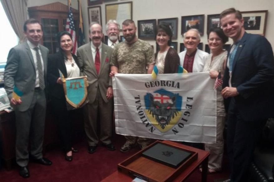 A group of people holding a flag

Description automatically generated with medium confidence