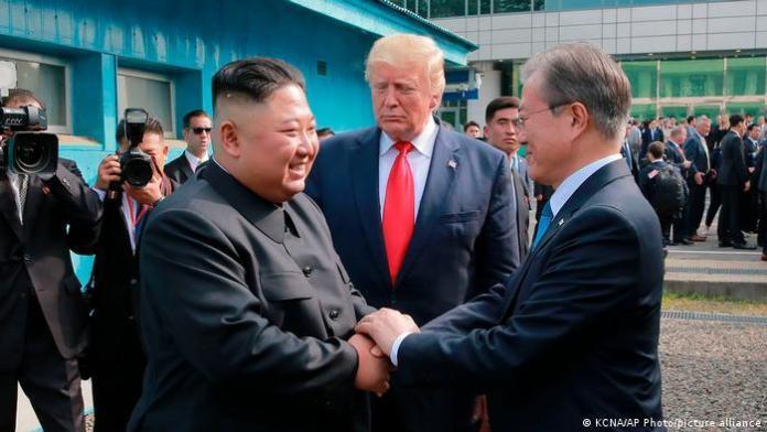 Donald Trump watches as Kim Jong Un and Moon Jae-in shake hands