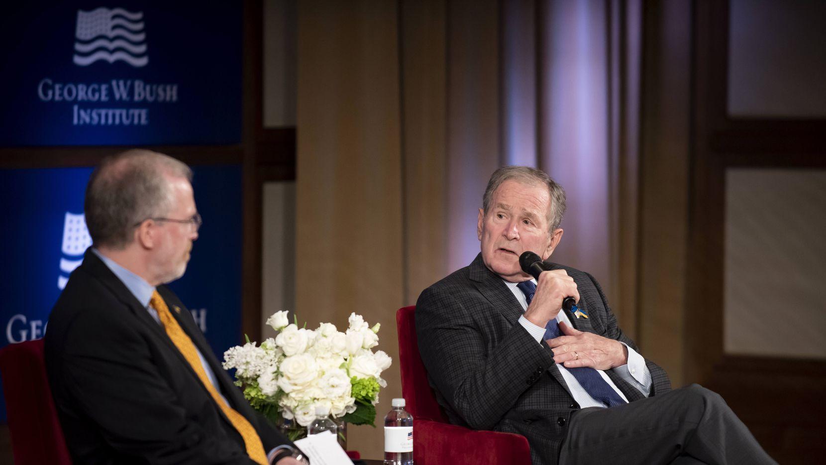 Former President George W. Bush speaks with David Kramer, the Executive Director of the...
