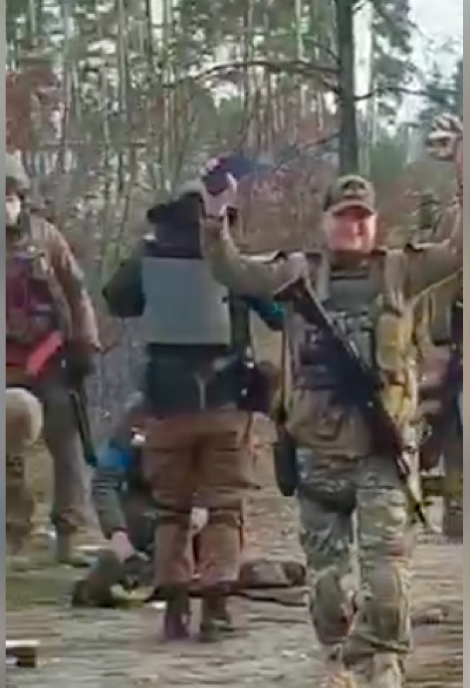 Screenshot of a video filmed by Ukrainian soldiers showing them around Russian soldiers lying on the ground outside a village west of Kiev in late March 2022.