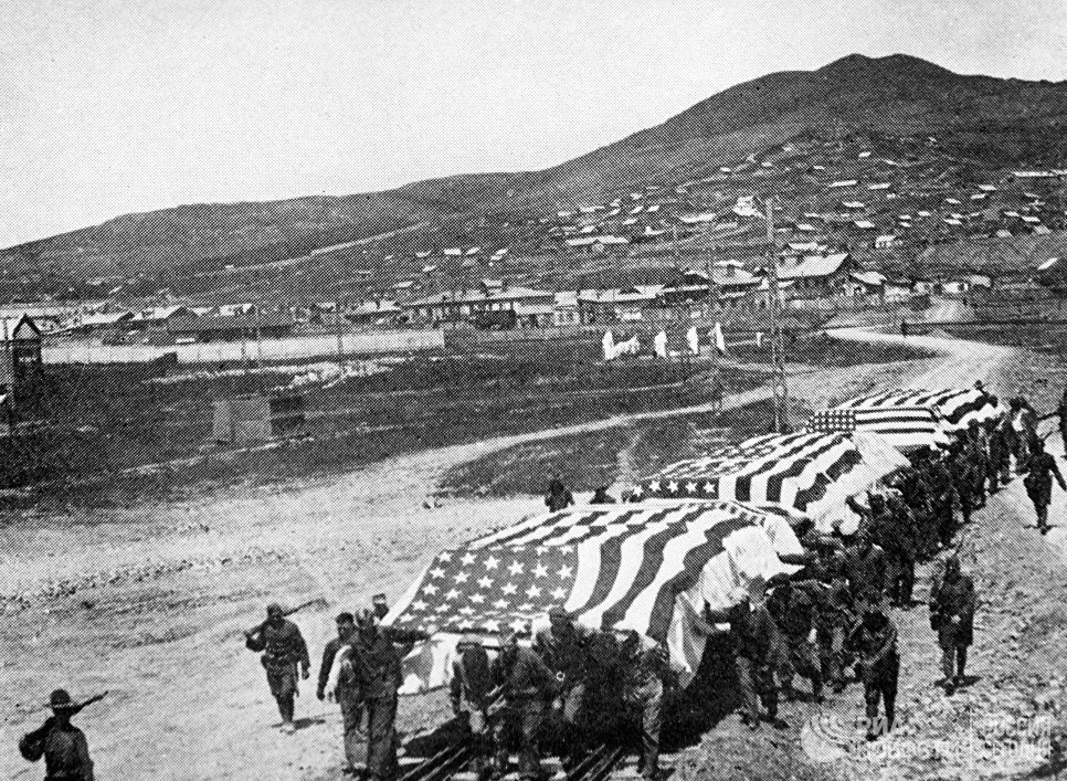 A group of people carrying a flag
Description automatically generated with low confidence
