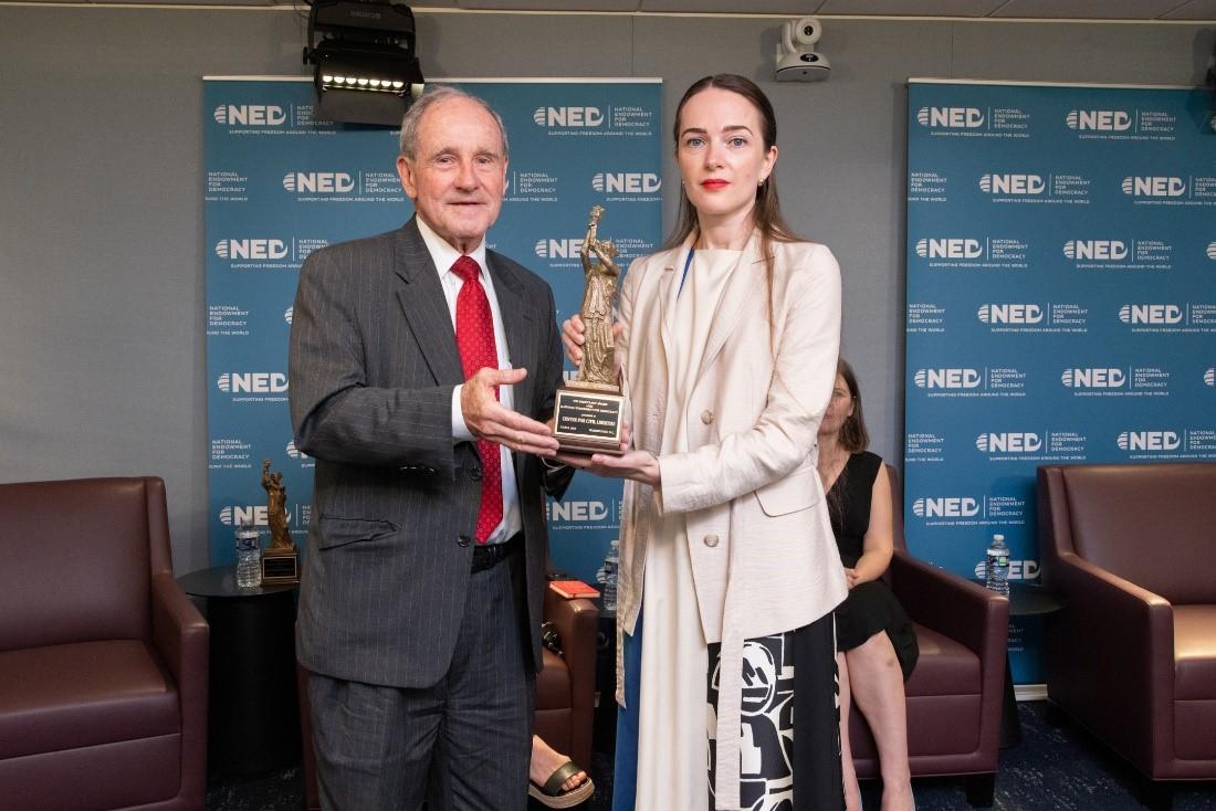 Two people holding a plaque

Description automatically generated with medium confidence