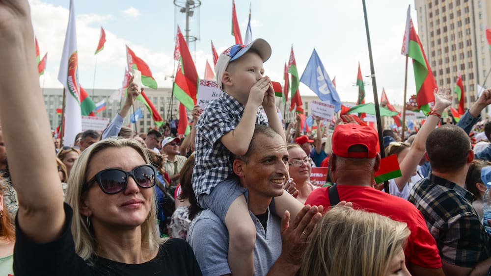 A group of people holding flags

Description automatically generated with medium confidence