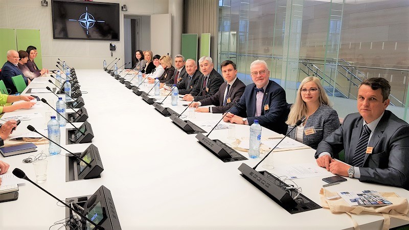 A group of people sitting at a table Description automatically generated with low confidence
