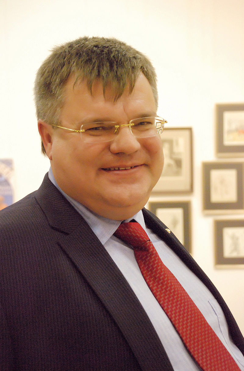 A person wearing glasses and a suit

Description automatically generated with medium confidence