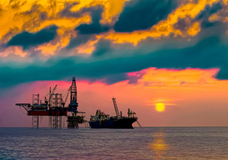 A group of oil rigs in the water during sunset

Description automatically generated with low confidence