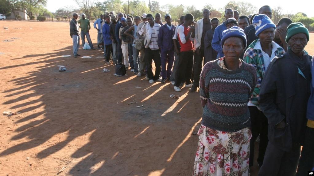 FILE - In this Sept. 16, 2008 file photo, Zimbabweans queue at Home Affairs offices in Musina, South Africa, close to the Zimbabwean border, to seek refugee status.