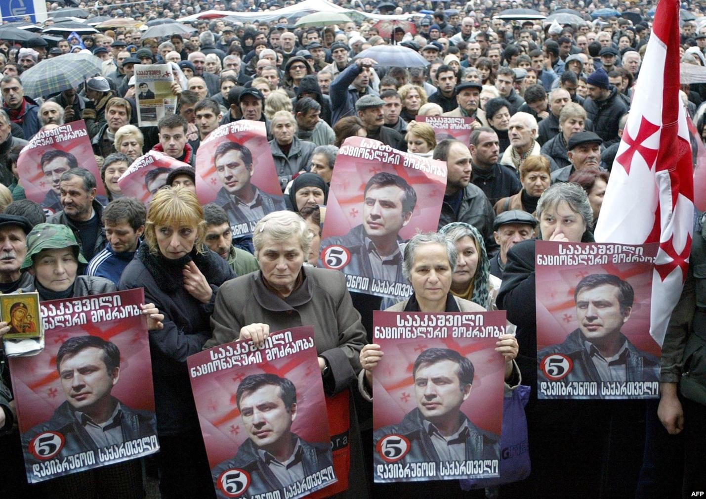 Georgian opposition supporters hold portraits of opposition leader Mikheil Saakashvili during a rally outside the parliament in Tbilisi on November 10, 2003.