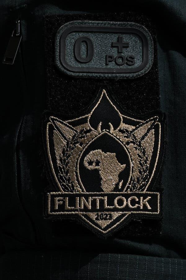 A close-up shot of the Flintlock badge on a military uniform.