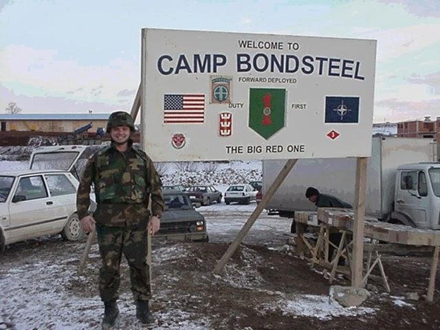 A person in military uniform standing in front of a sign

Description automatically generated with low confidence
