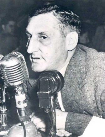 A person sitting at a microphone

Description automatically generated with low confidence
