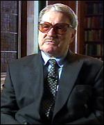 A person wearing glasses and a suit

Description automatically generated with medium confidence