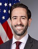 A person in a suit and tie

Description automatically generated with medium confidence
