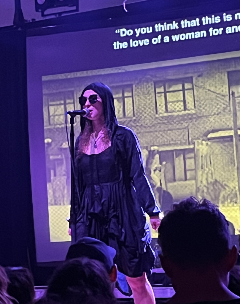 A person singing into a microphone

Description automatically generated with medium confidence
