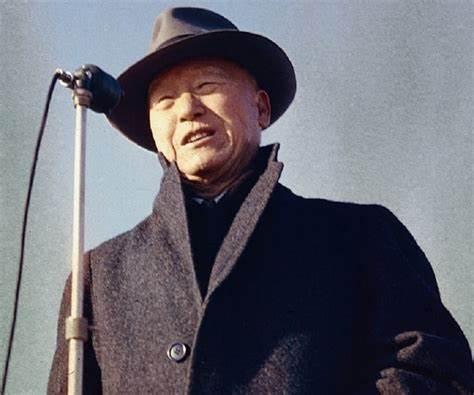 A person wearing a hat and standing at a microphone

Description automatically generated with medium confidence