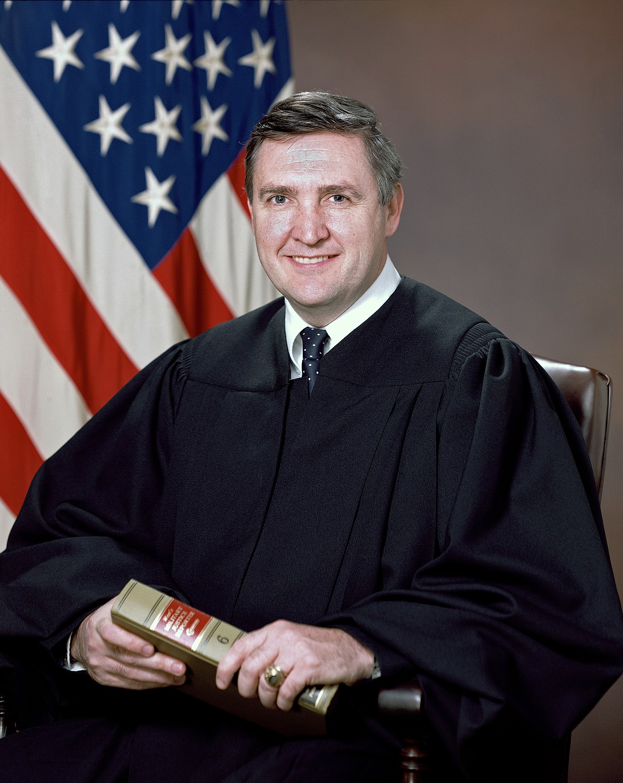 A person in a black robe holding a book

Description automatically generated with low confidence