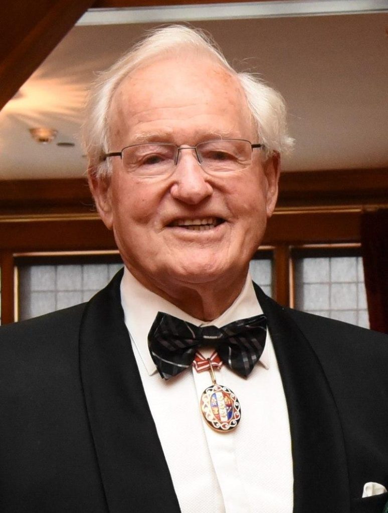 A person in a suit and bow tie

Description automatically generated with low confidence