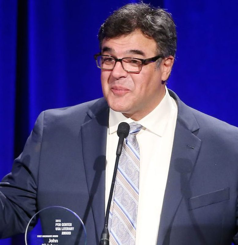 A person in a suit and tie standing at a podium

Description automatically generated with low confidence