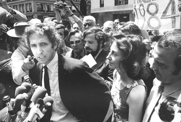 A person speaking into microphones with a crowd of people

Description automatically generated with low confidence