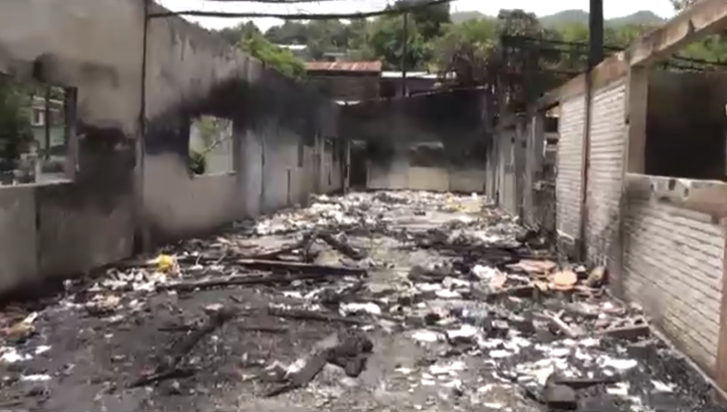A burned down building with debris on the ground

Description automatically generated