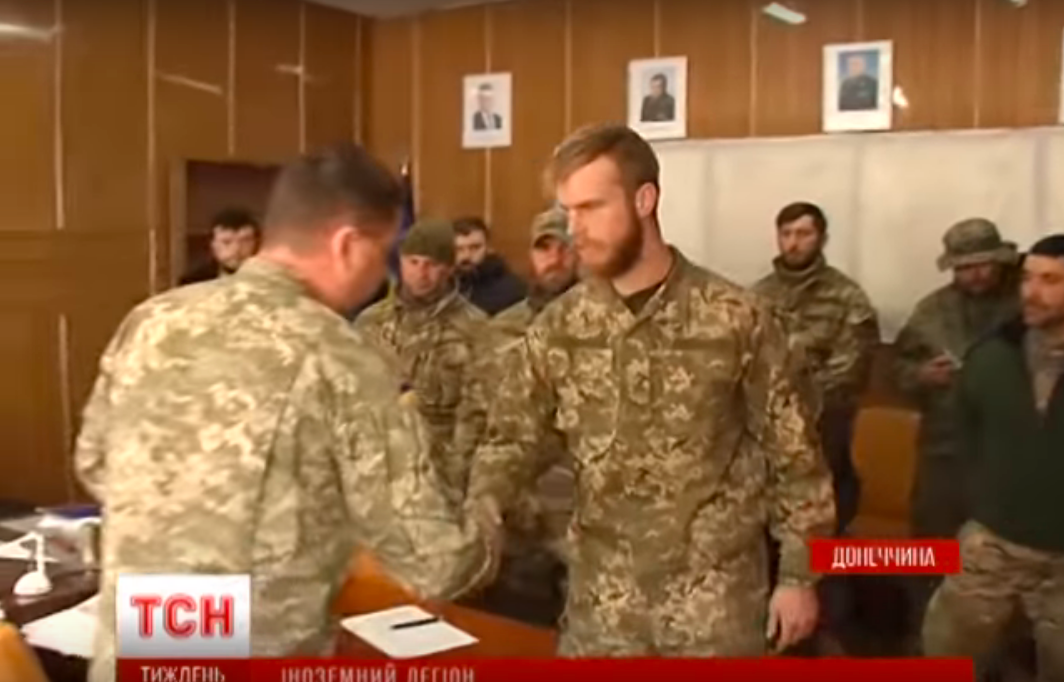 A group of men in military uniforms shaking hands

Description automatically generated