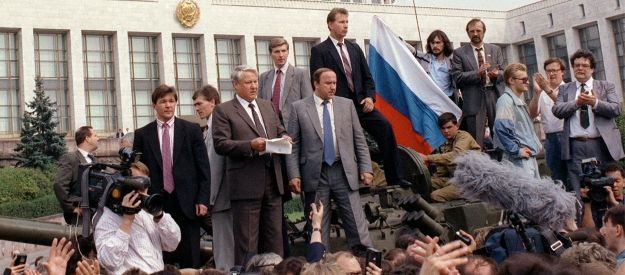 A group of men standing in front of a military vehicle
Description automatically generated with low confidence