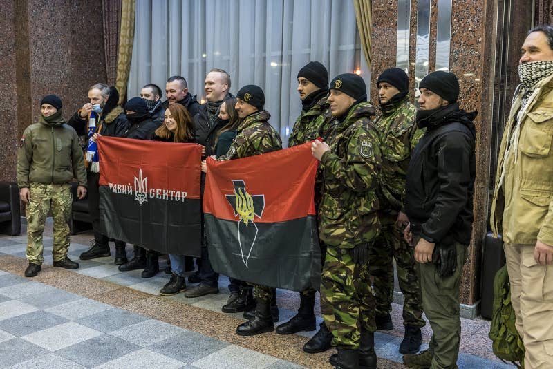 A group of people holding flags

Description automatically generated
