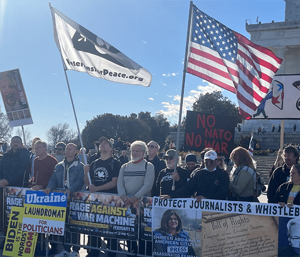 A group of people holding signs and flags

Description automatically generated with medium confidence