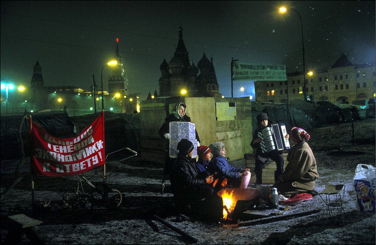 A group of people sitting around a fire
Description automatically generated with medium confidence