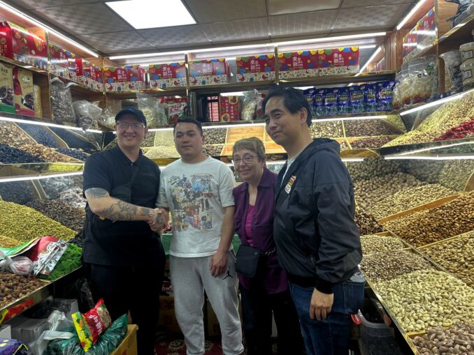 A group of people standing in a store

Description automatically generated