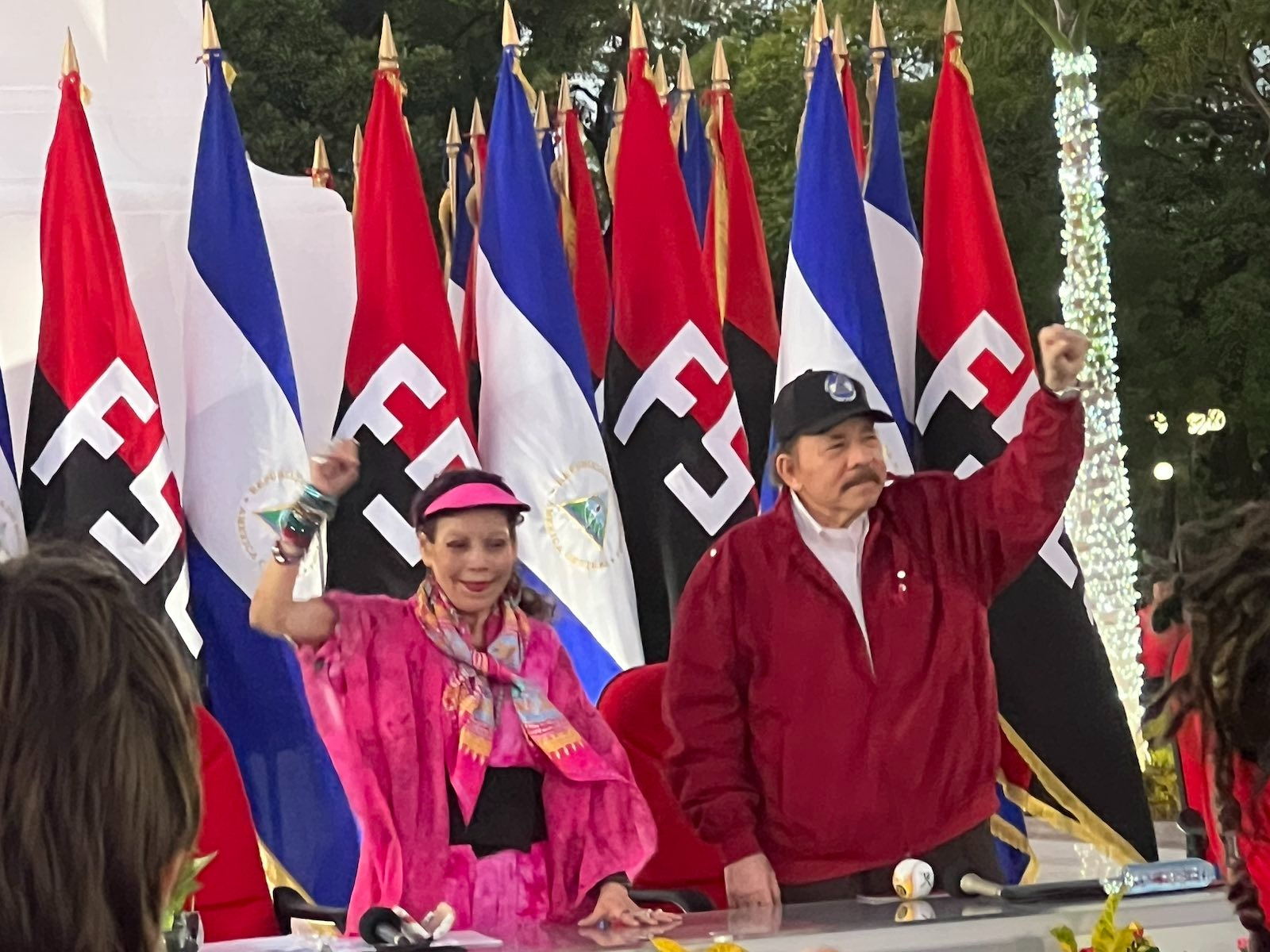 A group of people standing in front of flags

Description automatically generated