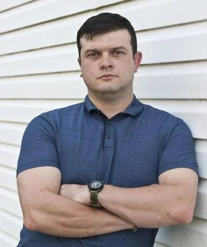 A person folding his arms Description automatically generated