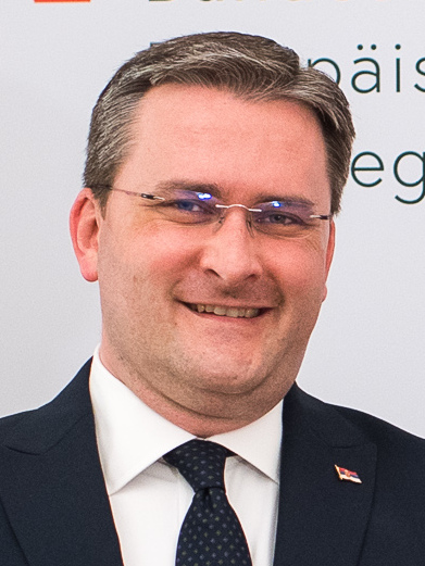 A person in a suit and tie

Description automatically generated with medium confidence