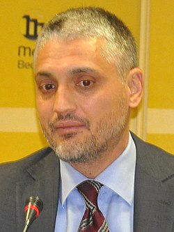 A person in a suit and tie

Description automatically generated with medium confidence