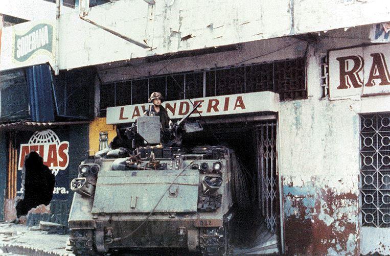 A person standing in front of a tank

Description automatically generated