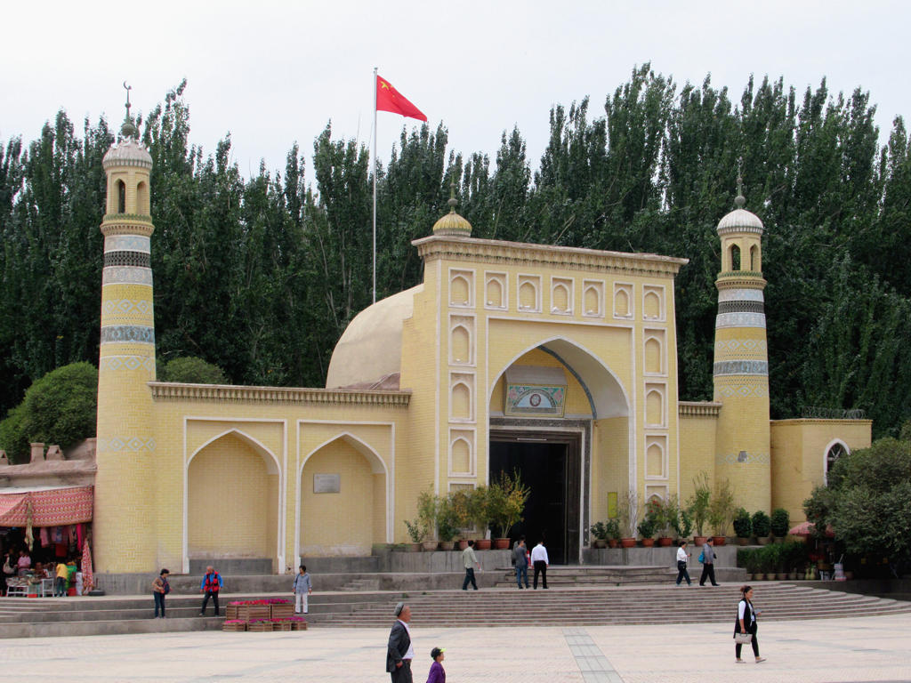 A yellow building with towers and a flag

Description automatically generated with low confidence