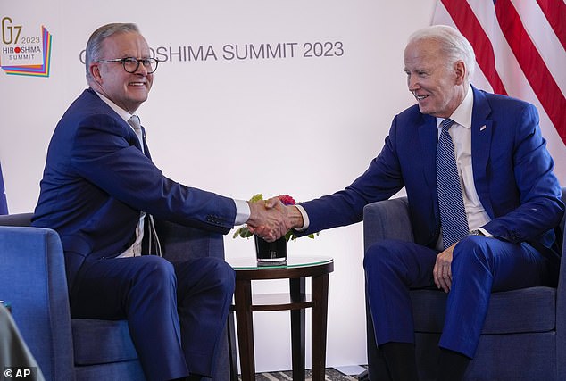 Two men in suits shaking hands

Description automatically generated with medium confidence