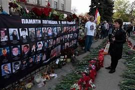 A group of people standing next to a wall with flowers and pictures

Description automatically generated