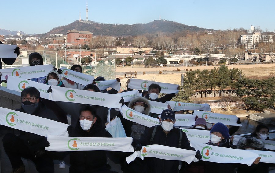 A group of people wearing face masks holding banners

Description automatically generated