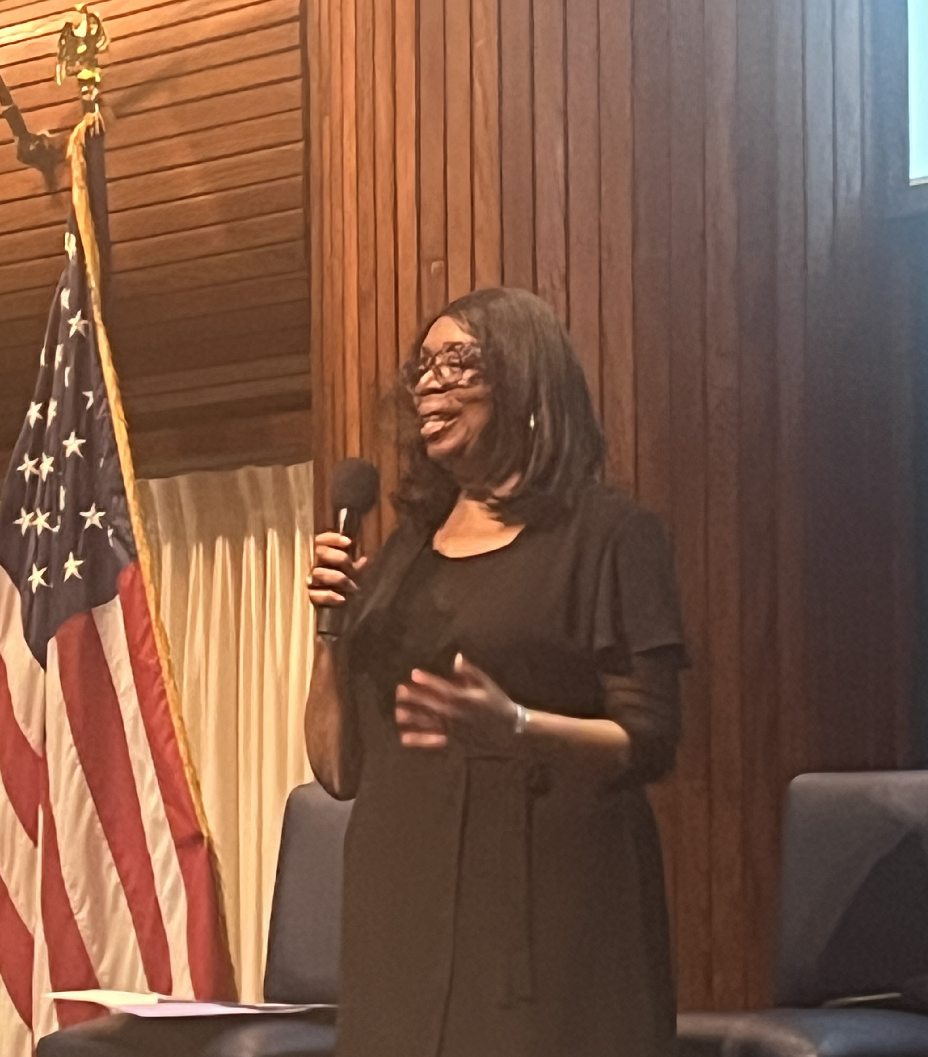 A person holding a microphone

Description automatically generated
