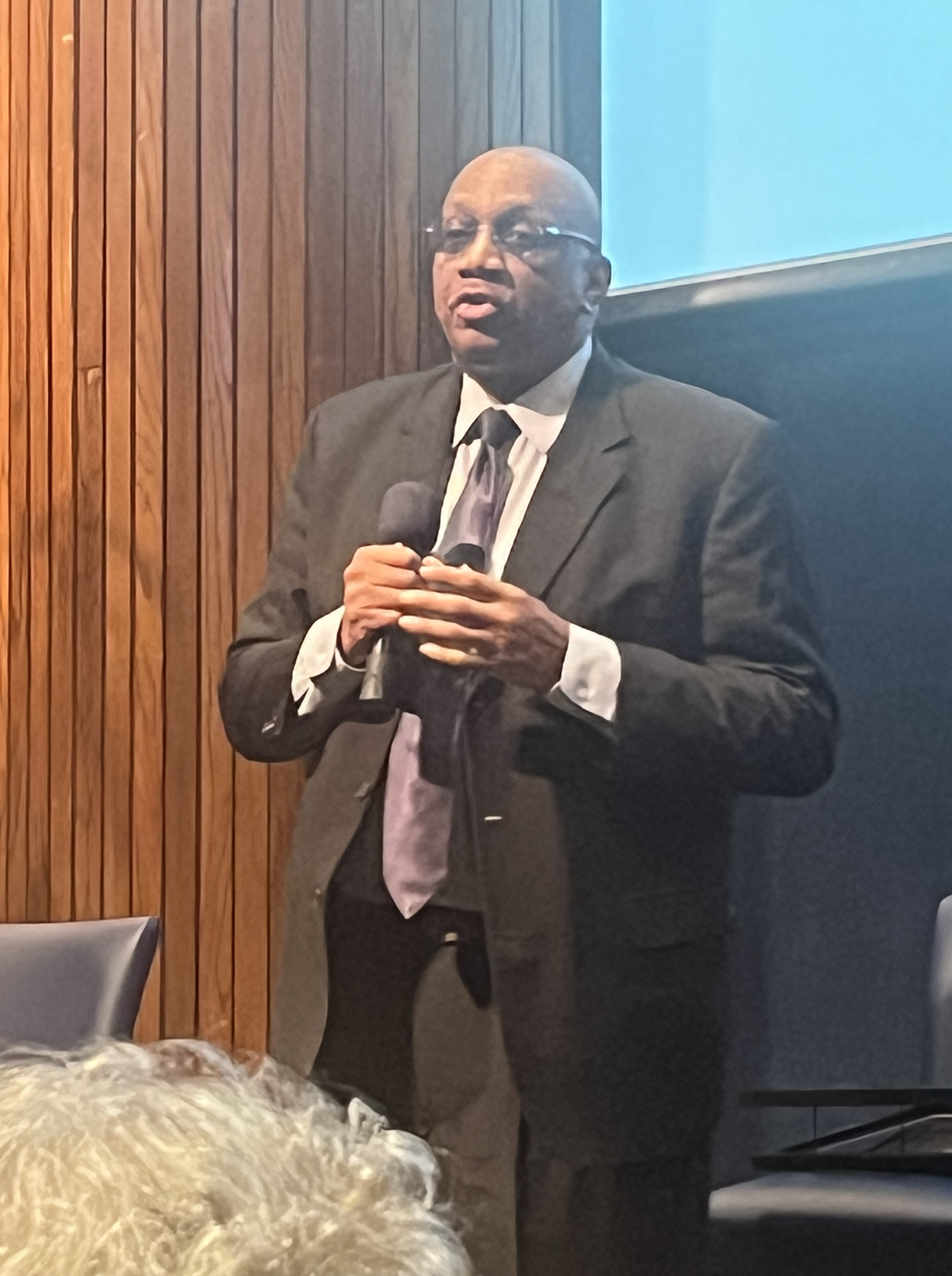 A person in a suit holding a microphone

Description automatically generated