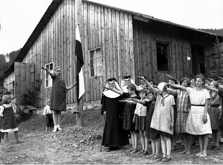 A group of children standing in front of a building

Description automatically generated