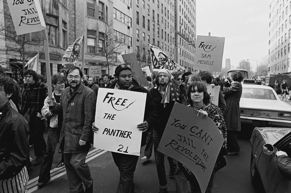 A group of people marching in a protest

Description automatically generated