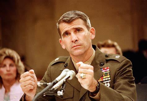 A person in military uniform speaking into microphones

Description automatically generated
