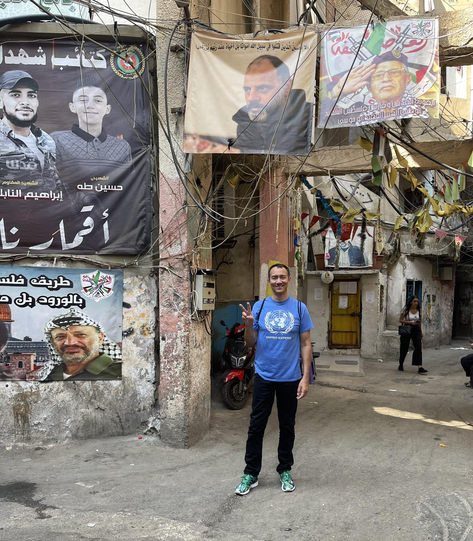 A person standing in front of a wall with posters on it

Description automatically generated