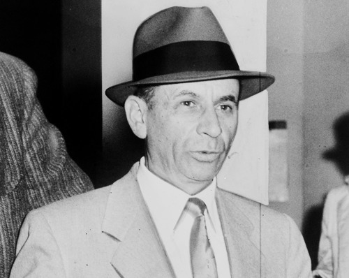 A person wearing a hat and suit

Description automatically generated