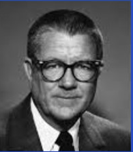 A person wearing glasses and a suit

Description automatically generated