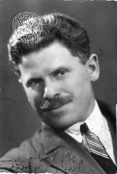 A person with a mustache wearing a crown Description automatically generated