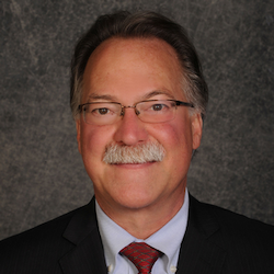 A person with a mustache wearing glasses

Description automatically generated